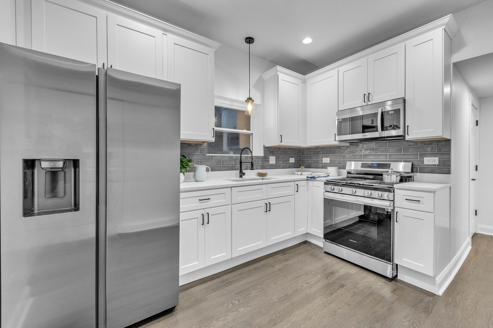 4844 West 23rd Street Cicero, IL 60804 - Photo 23 of 36 a kitchen with stainless steel appliances granite countertop white cabinets a sink a stove a refrigerator and a microwave