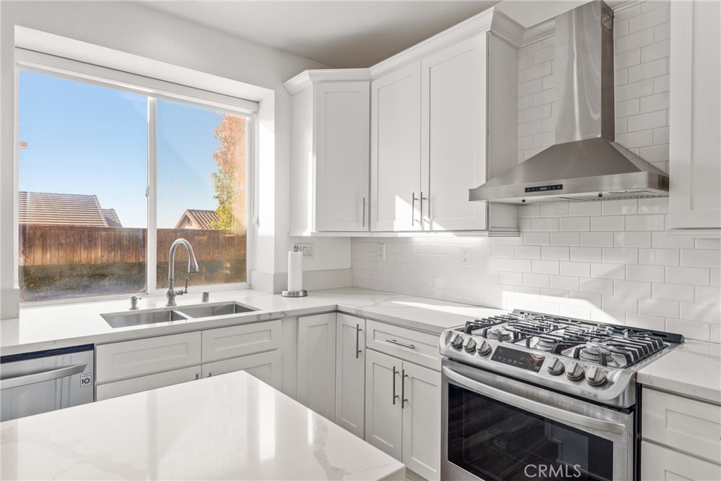 9749 Orange Street Rancho Cucamonga, CA 91737 - Photo 13 of 38 a kitchen with stainless steel appliances a stove a sink and a white cabinets