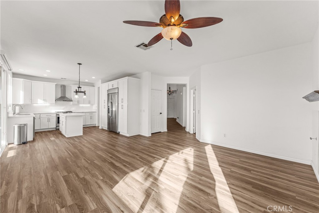 9749 Orange Street Rancho Cucamonga, CA 91737 - Photo 10 of 38 a view of a kitchen with wooden floor and a ceiling fan
