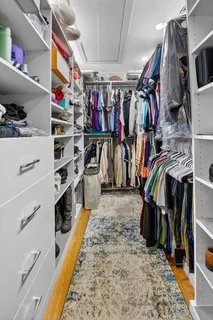 a view of walk in closet with clothes and shoes