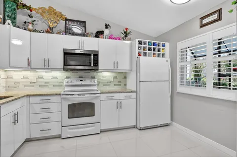 a kitchen with white cabinets and white appliances