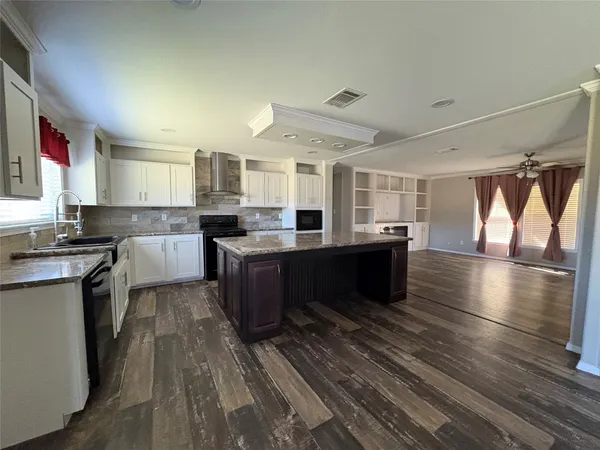 a large kitchen with stainless steel appliances granite countertop a lot of counter space and wooden floor