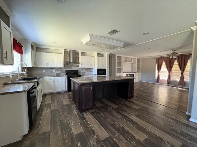 a large kitchen with stainless steel appliances granite countertop a lot of counter space and wooden floor