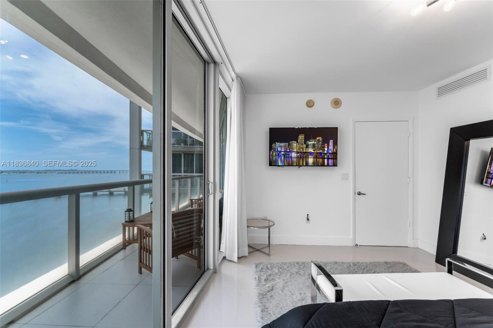 495 Brickell Avenue, Unit BAY1007 Miami, FL 33131 - Photo 12 of 34 a bedroom with a bed and a flat screen tv