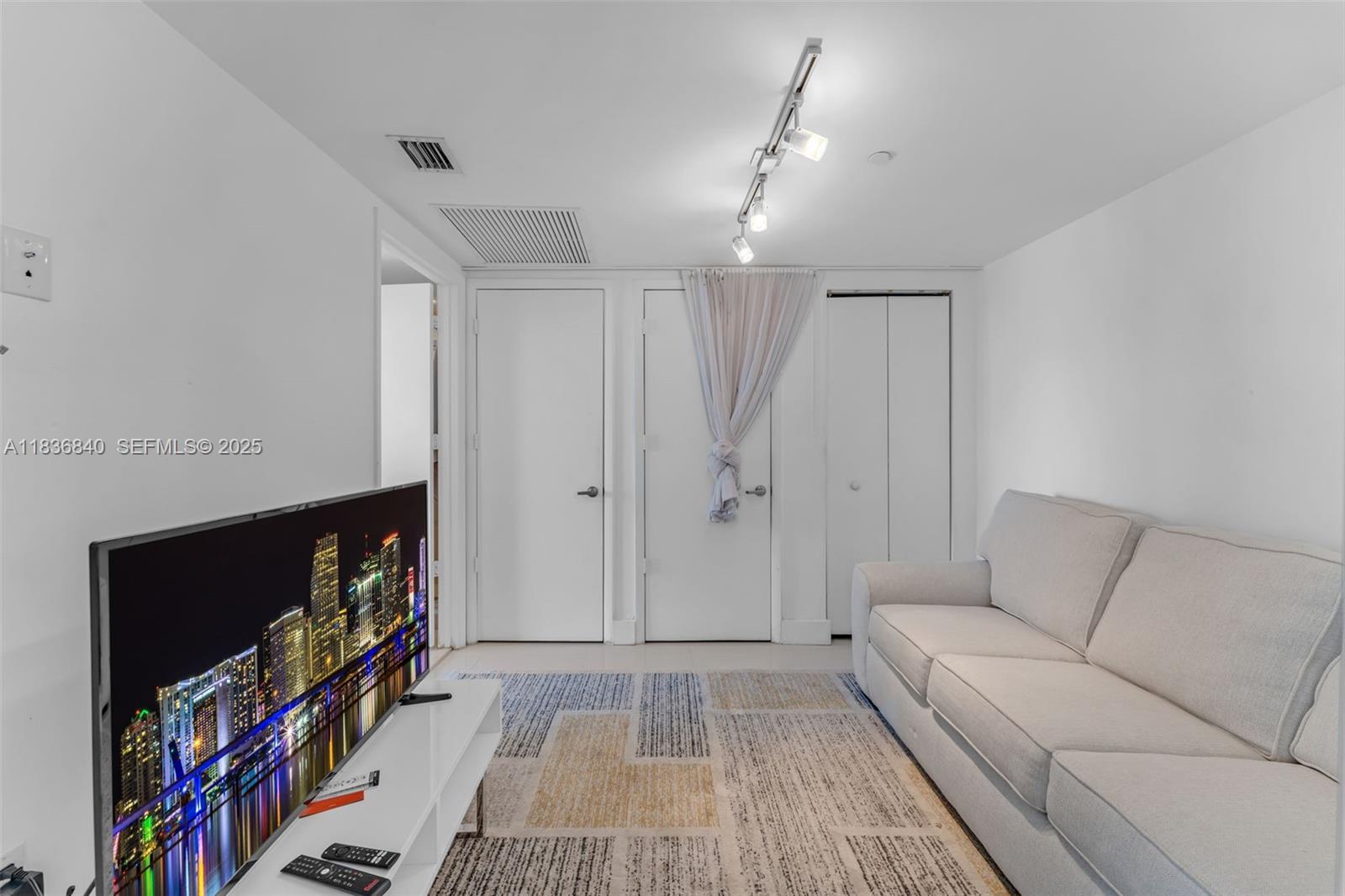 495 Brickell Avenue, Unit BAY1007 Miami, FL 33131 - Photo 20 of 34 a living room with furniture and a flat screen tv