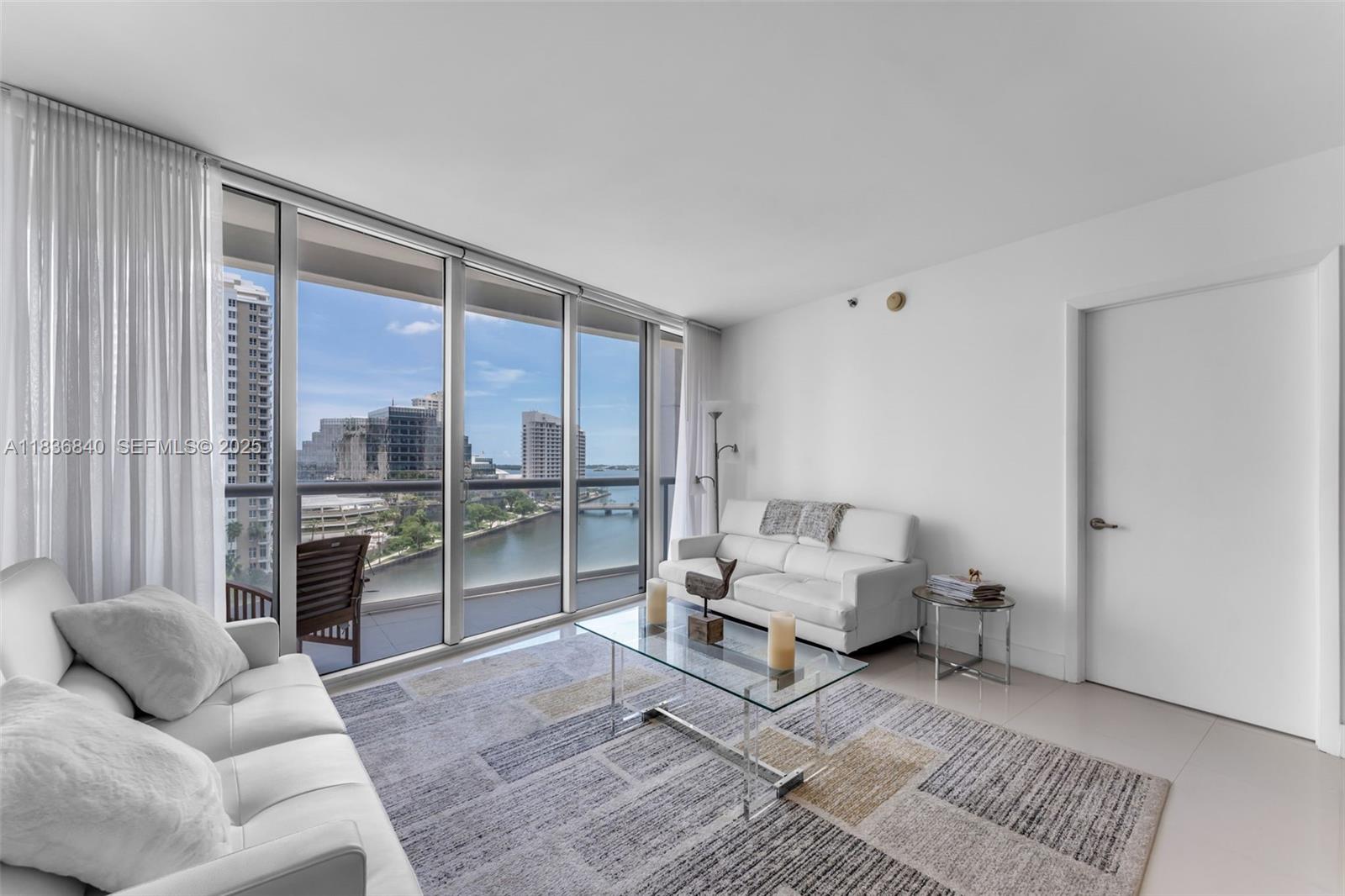 495 Brickell Avenue, Unit BAY1007 Miami, FL 33131 - Photo 6 of 34 a living room with furniture and large windows