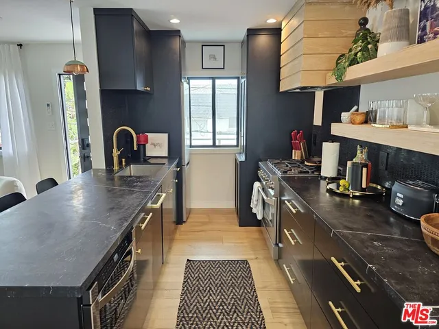 a kitchen with stainless steel appliances granite countertop a sink stove and refrigerator