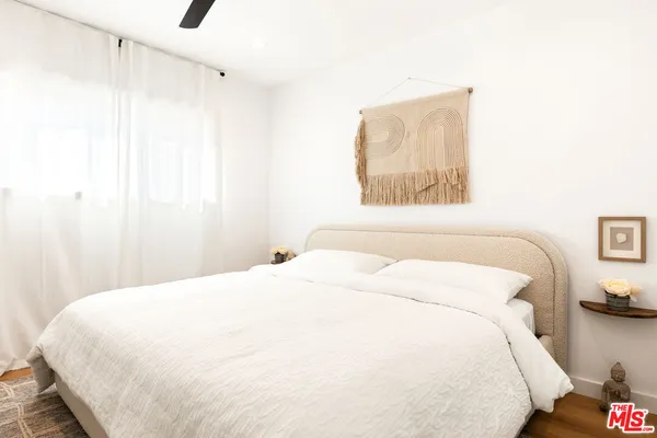 a bedroom with a bed and a painting on the wall