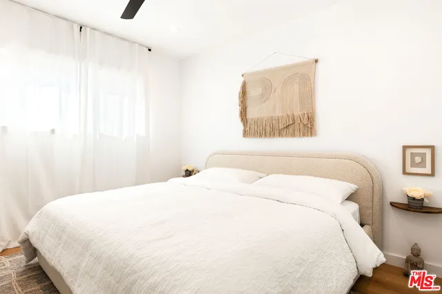 a bedroom with a bed and a painting on the wall