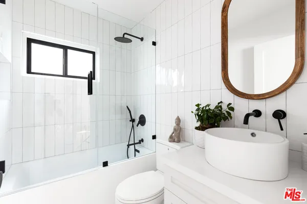 a bathroom with a sink a bathtub and a mirror