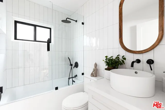 a bathroom with a sink a bathtub and a mirror