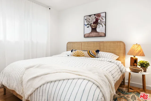 a bedroom with a bed and a painting on the wall