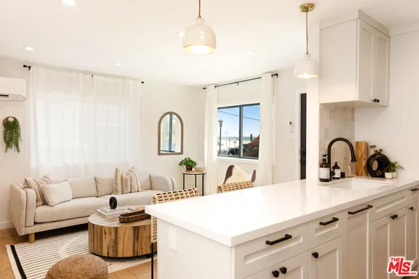 a living room with furniture a couch and kitchen view