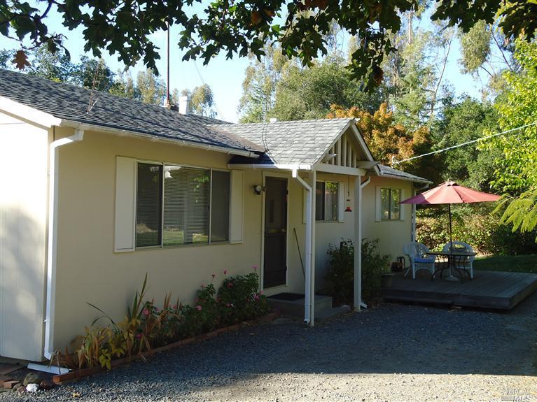 4902 Maddocks Road Sebastopol, CA 95472 - Photo 1 of 1 a backyard of a house with table and chairs with wooden fence and plants