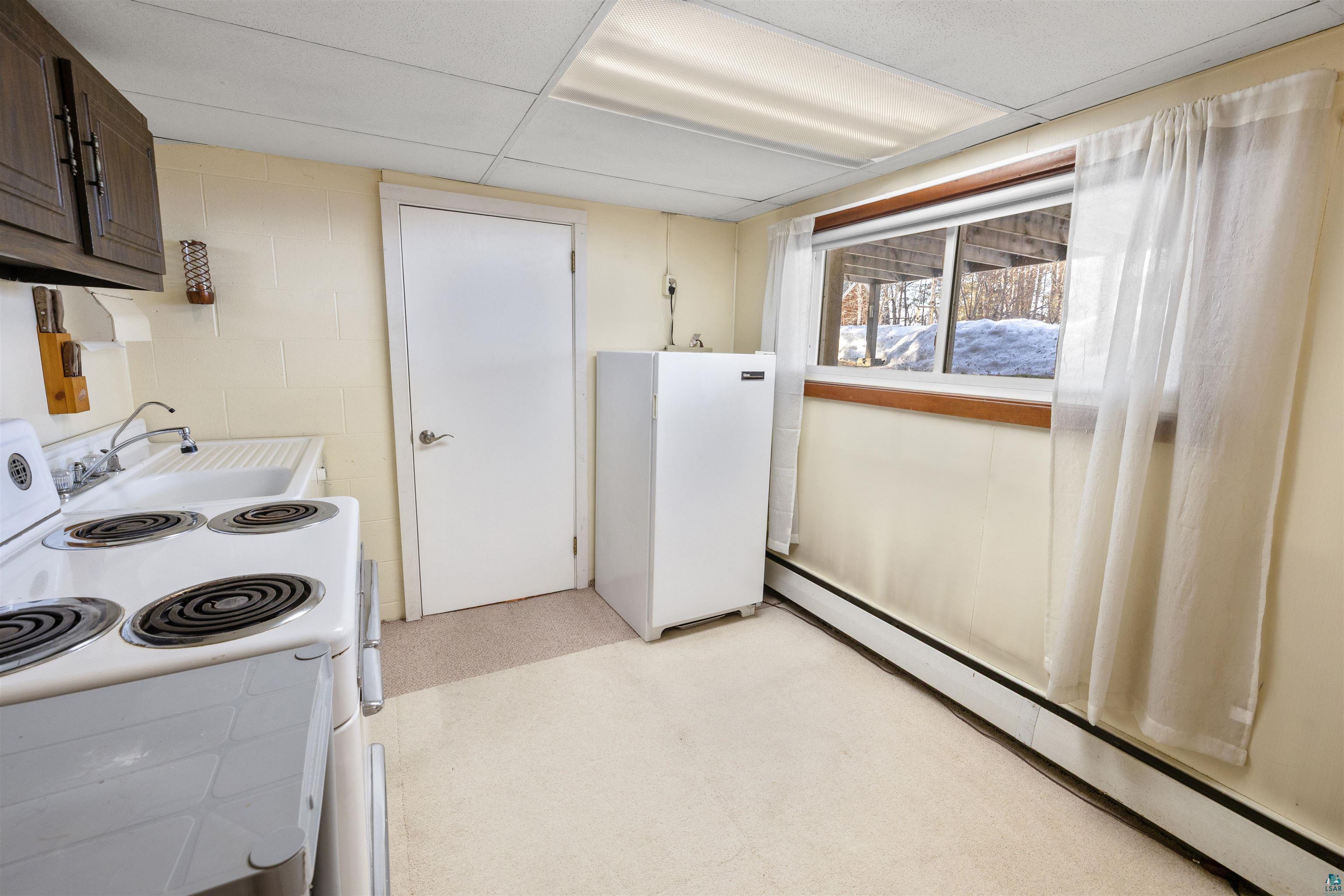 3975 Long Lake Shores Road Eveleth, MN 55734 - Photo 54 of 84 Kitchen with a baseboard heating unit, white appliances, light countertops, and light floors