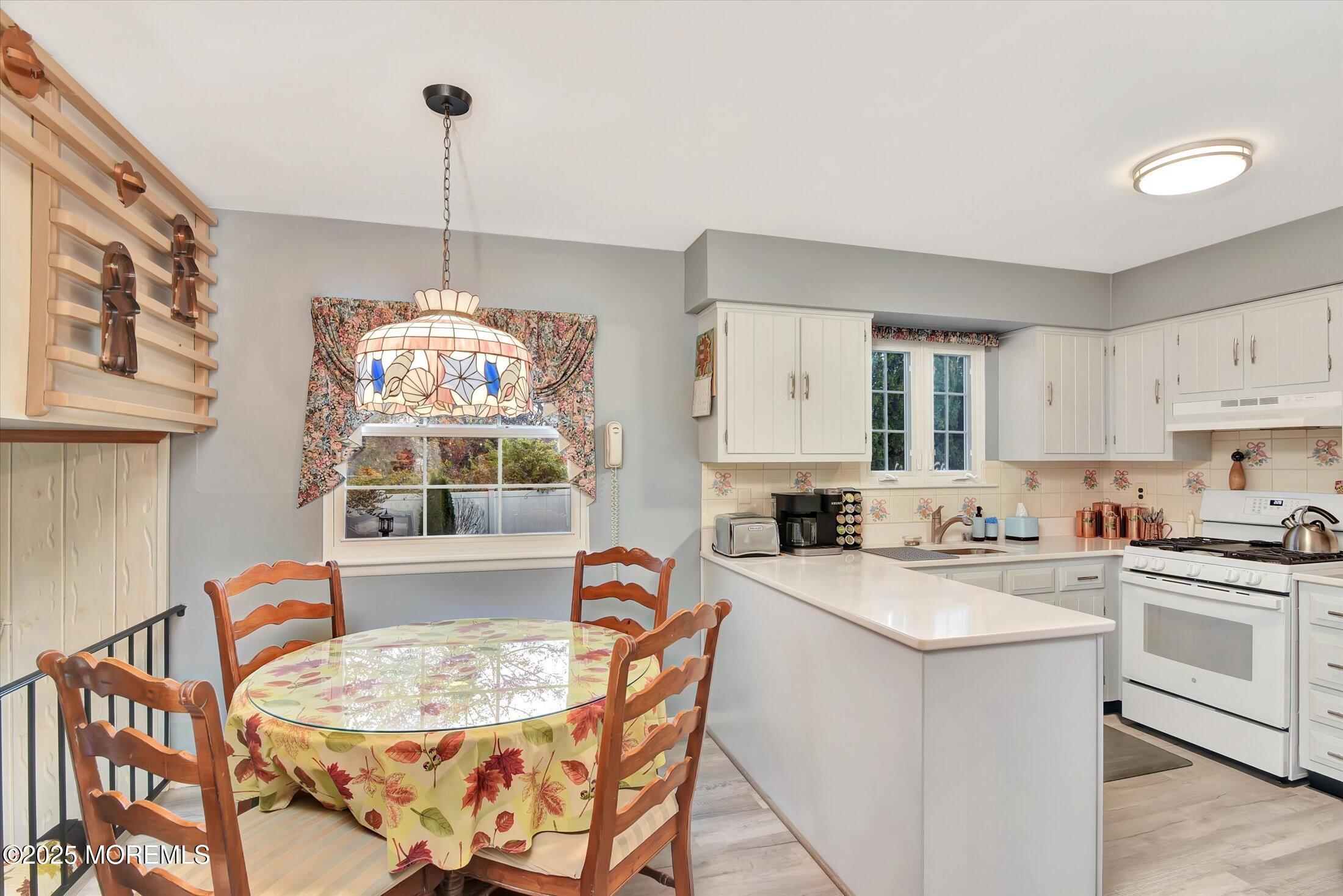 7 Nantucket Court Howell, NJ 07731 - Photo 14 of 39 a kitchen with stainless steel appliances granite countertop a sink a stove a dining table and chairs with wooden floor