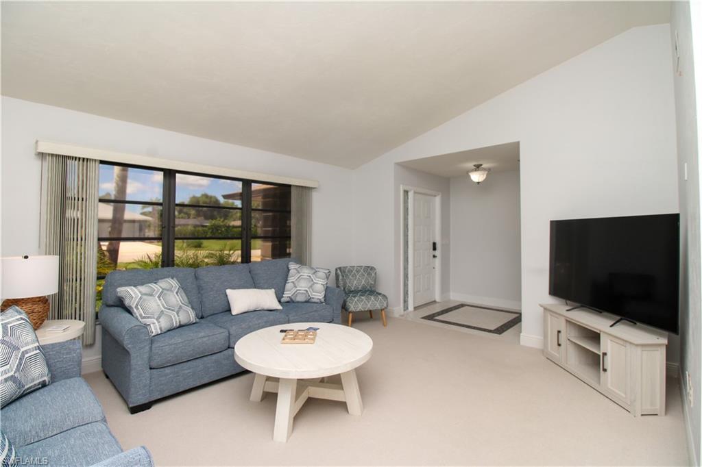 213 Bay Meadows Drive Naples, FL 34113 - Photo 13 of 50 a living room with furniture and a flat screen tv