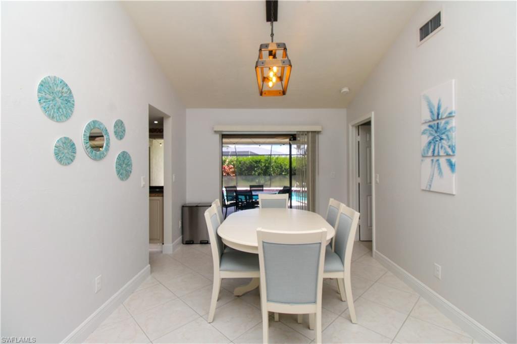 213 Bay Meadows Drive Naples, FL 34113 - Photo 16 of 50 a view of a dining room with furniture a rug and a window