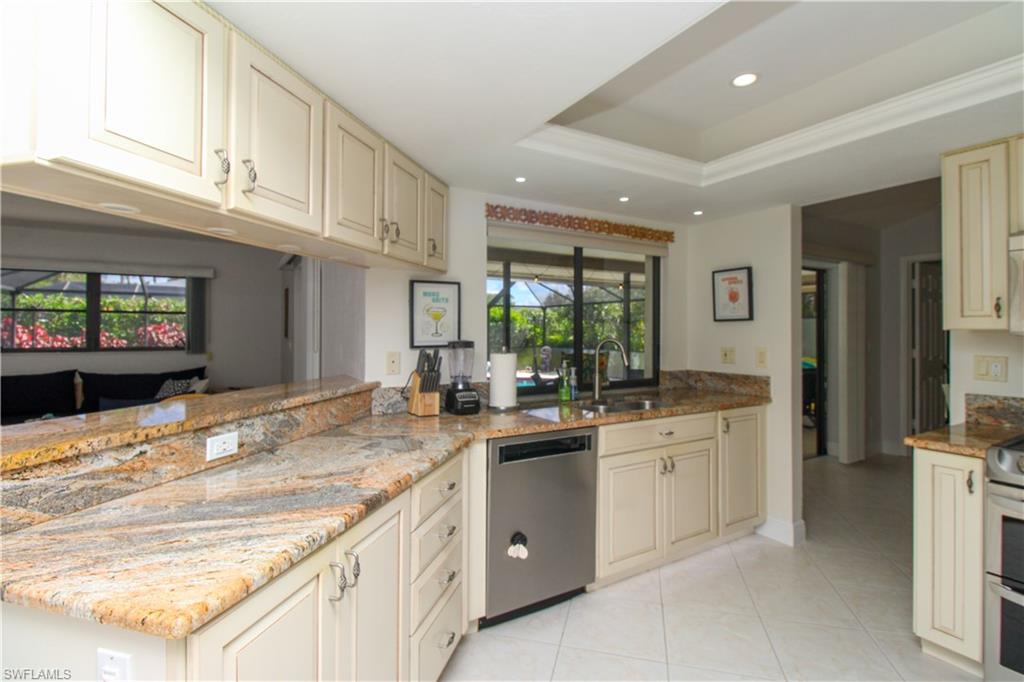 213 Bay Meadows Drive Naples, FL 34113 - Photo 19 of 50 a kitchen with granite countertop a sink and white cabinets