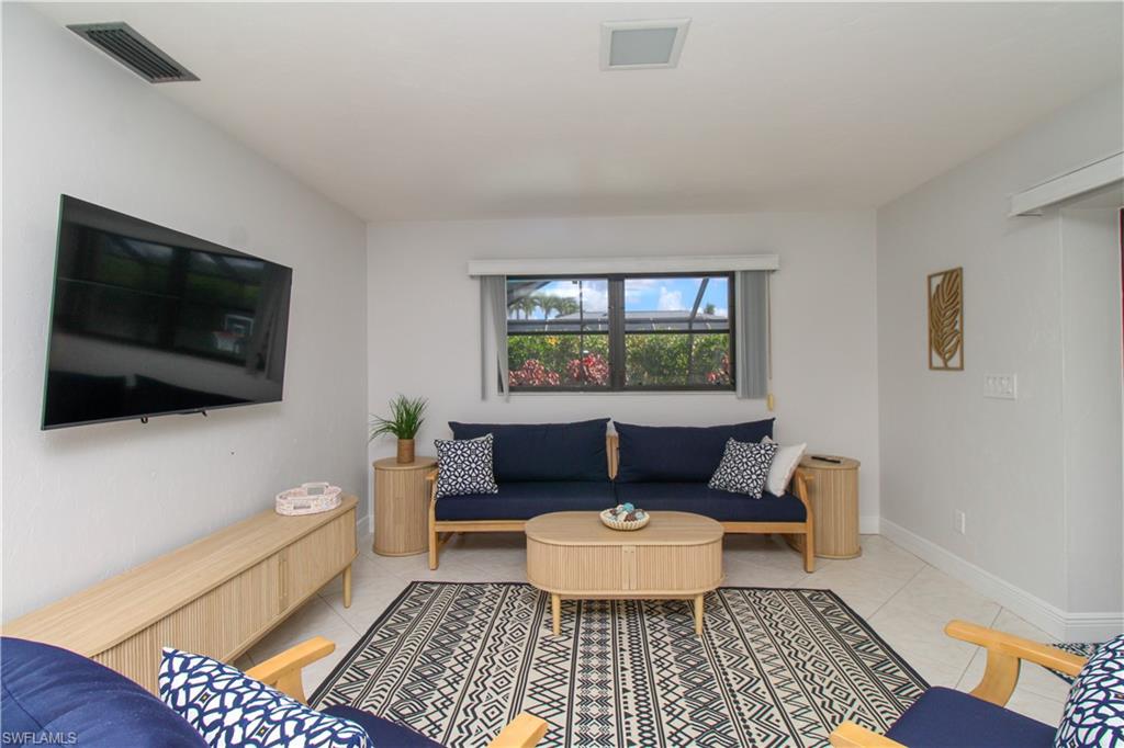213 Bay Meadows Drive Naples, FL 34113 - Photo 25 of 50 a living room with furniture and a flat screen tv