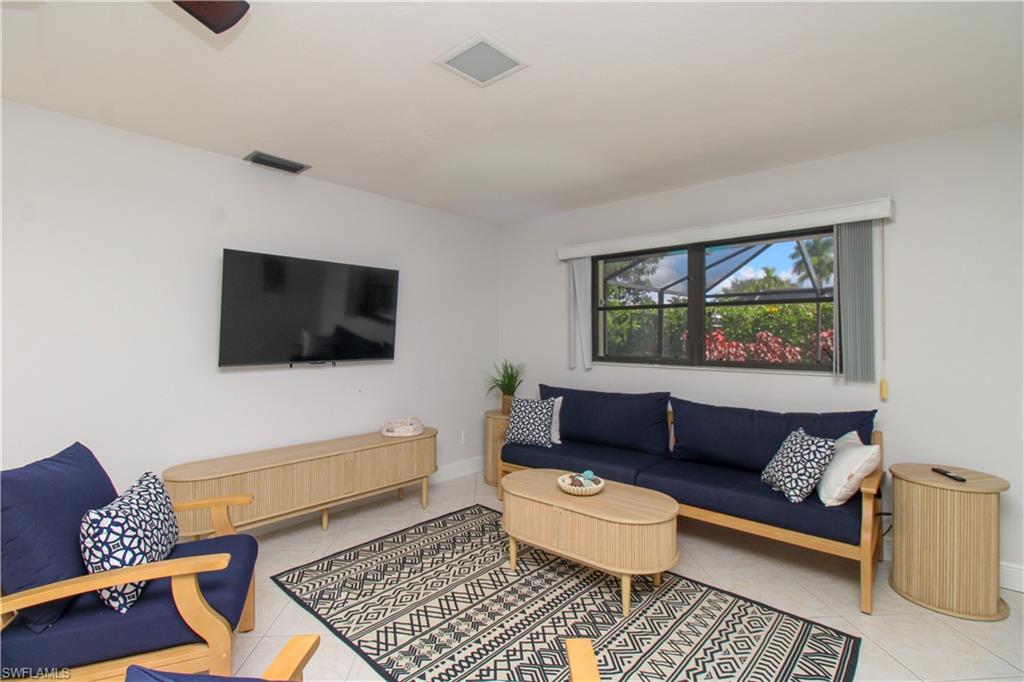 213 Bay Meadows Drive Naples, FL 34113 - Photo 26 of 50 a living room with furniture and a flat screen tv
