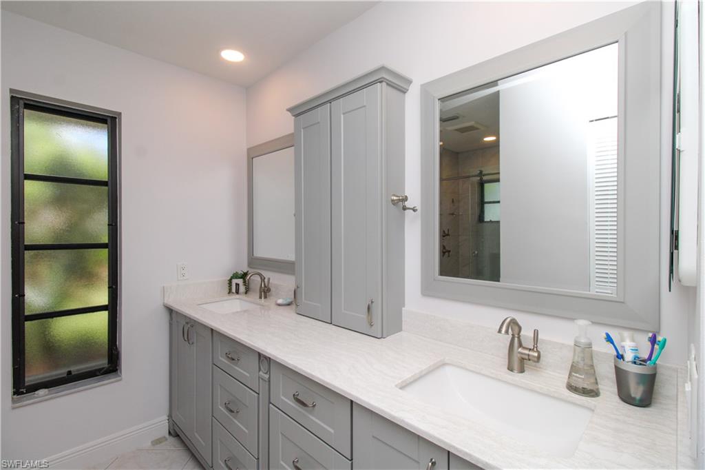 213 Bay Meadows Drive Naples, FL 34113 - Photo 31 of 50 a bathroom with double vanity sink and a mirror