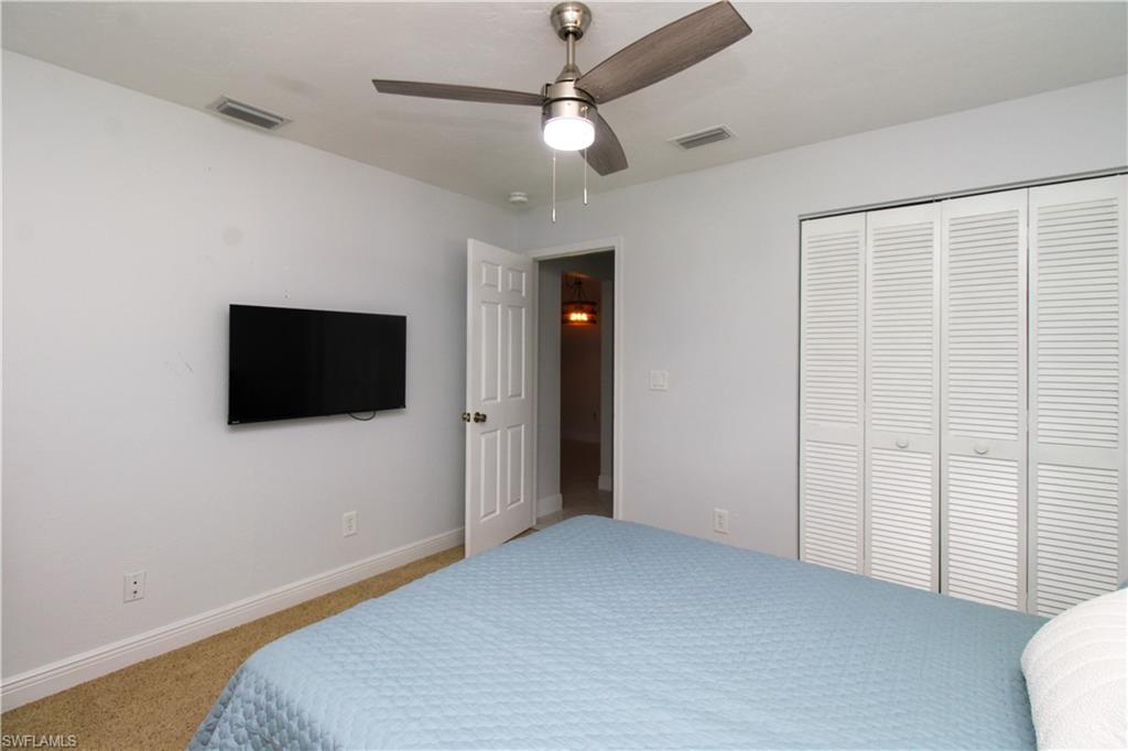 213 Bay Meadows Drive Naples, FL 34113 - Photo 35 of 50 a bedroom with a bed and a flat screen tv