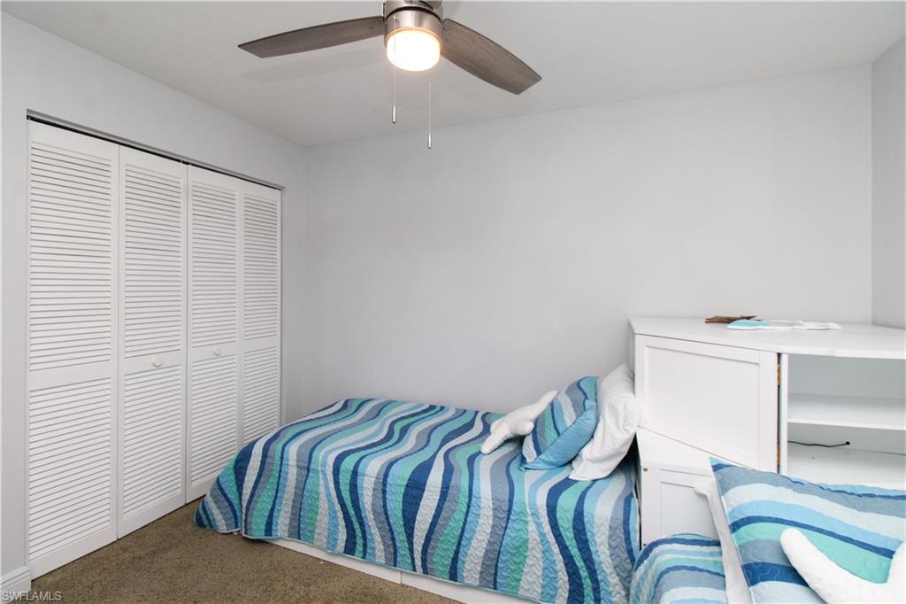 213 Bay Meadows Drive Naples, FL 34113 - Photo 39 of 50 a bedroom with a bed and chandelier