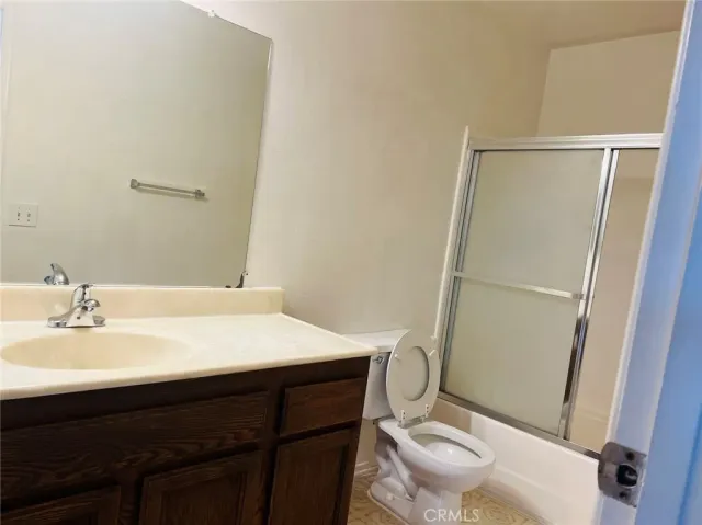 a bathroom with a sink a toilet a mirror and shower
