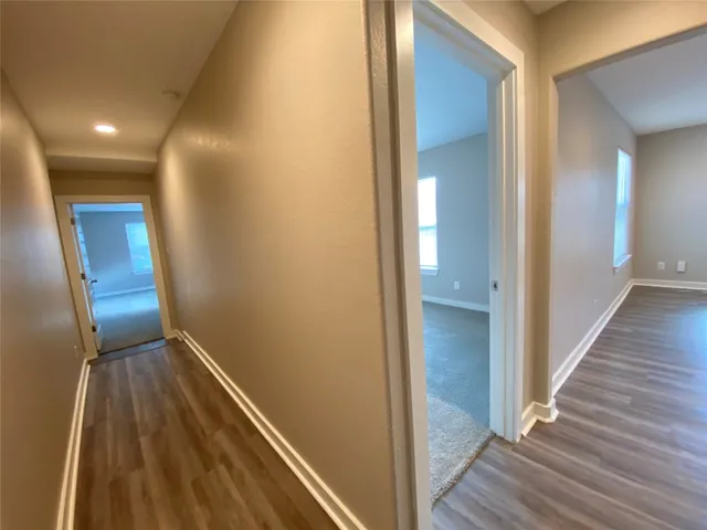 a view of a hallway with wooden floor