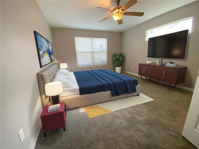 an empty room with windows and chandelier fan