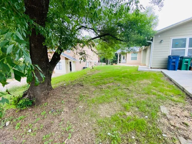 a view of a house with backyard and trees