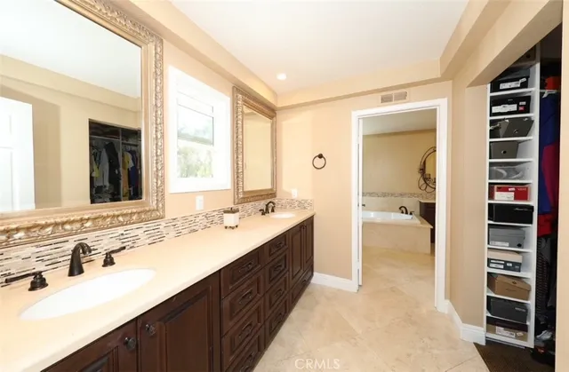 a spacious bathroom with a double vanity sink and a large mirror