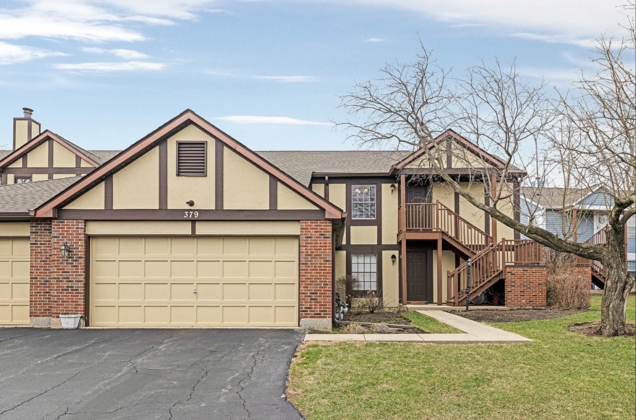 379 Sandhurst Circle, Unit 1 Glen Ellyn, IL 60137 - Photo 1 of 20 a front view of a house with a yard and garage