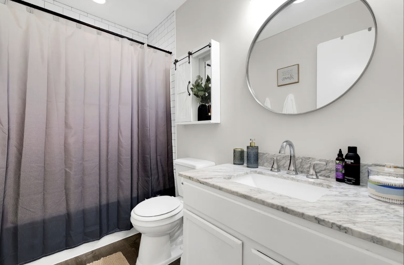 379 Sandhurst Circle, Unit 1 Glen Ellyn, IL 60137 - Photo 12 of 20 a bathroom with a sink a toilet and a mirror