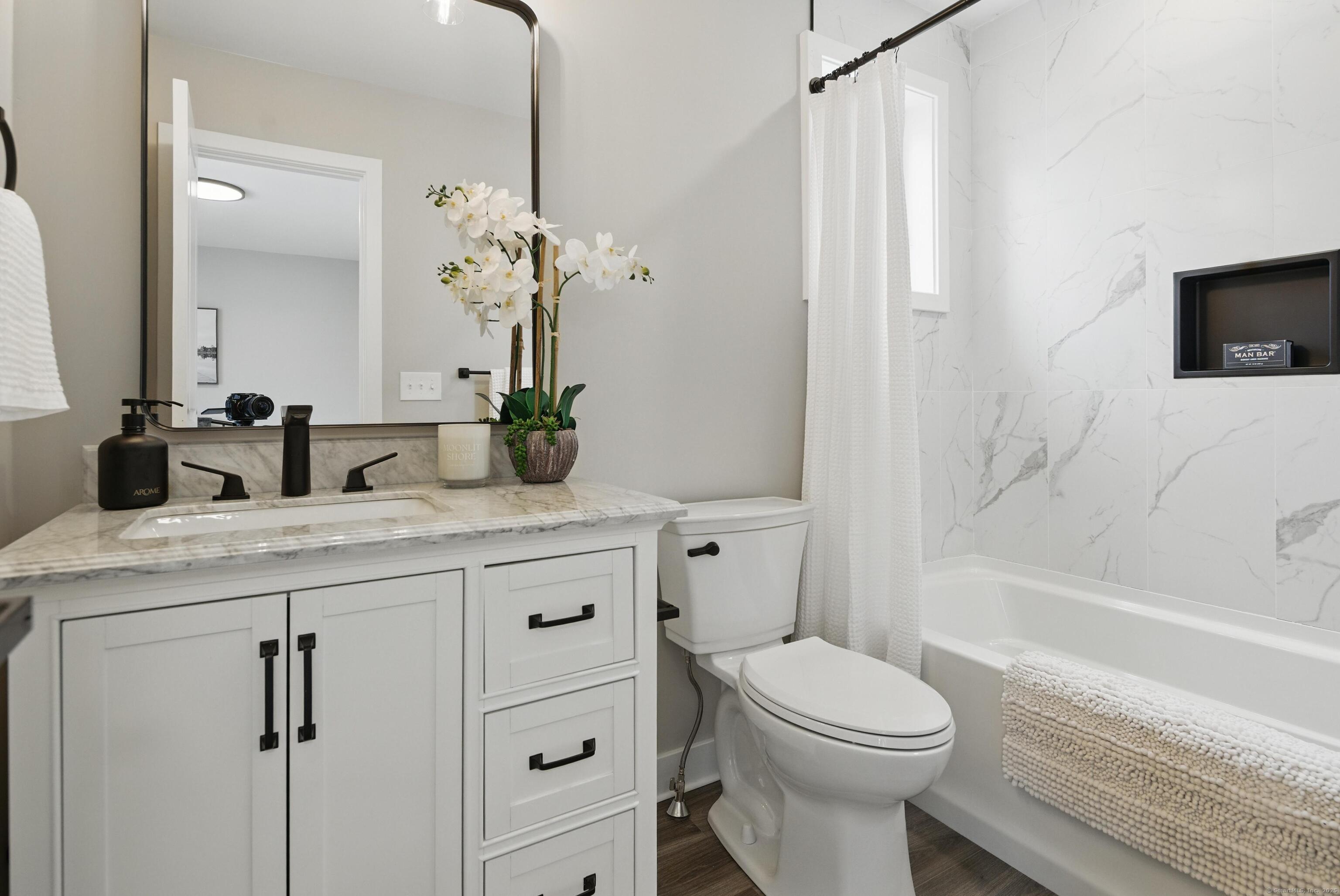 409 Prospect Avenue, Unit 5 West Hartford, CT 06119 - Photo 14 of 25 a bathroom with a granite countertop toilet sink and mirror