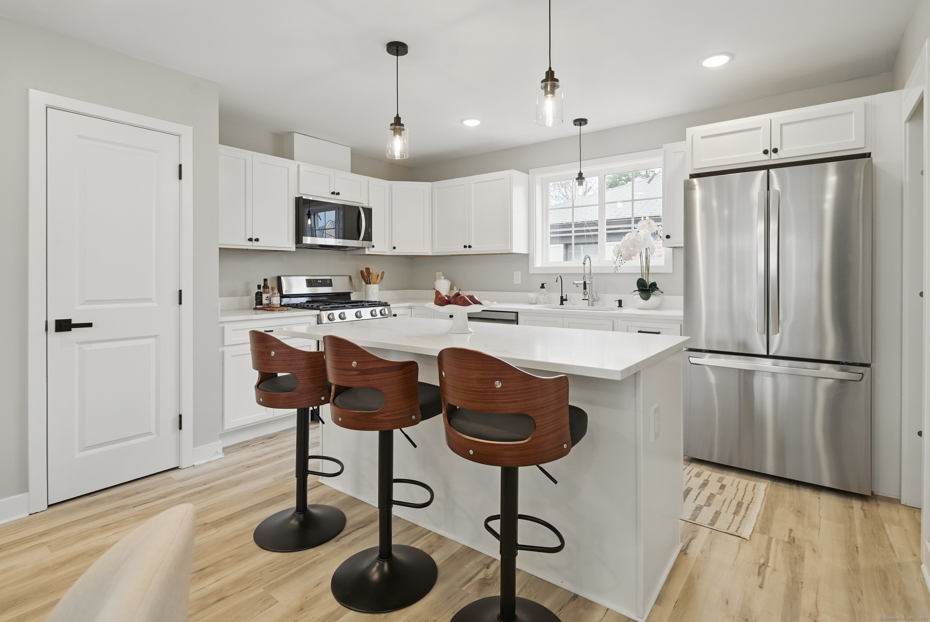 409 Prospect Avenue, Unit 5 West Hartford, CT 06119 - Photo 7 of 25 a kitchen with stainless steel appliances granite countertop a sink a stove a refrigerator cabinets and chairs