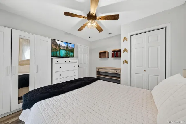 a bedroom with a bed and a ceiling fan