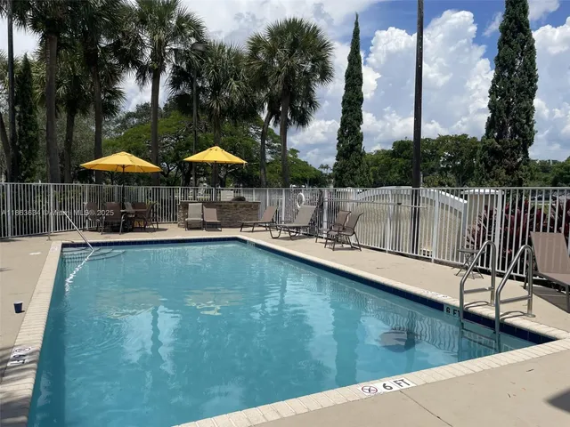 a view of a swimming pool with chairs in patio