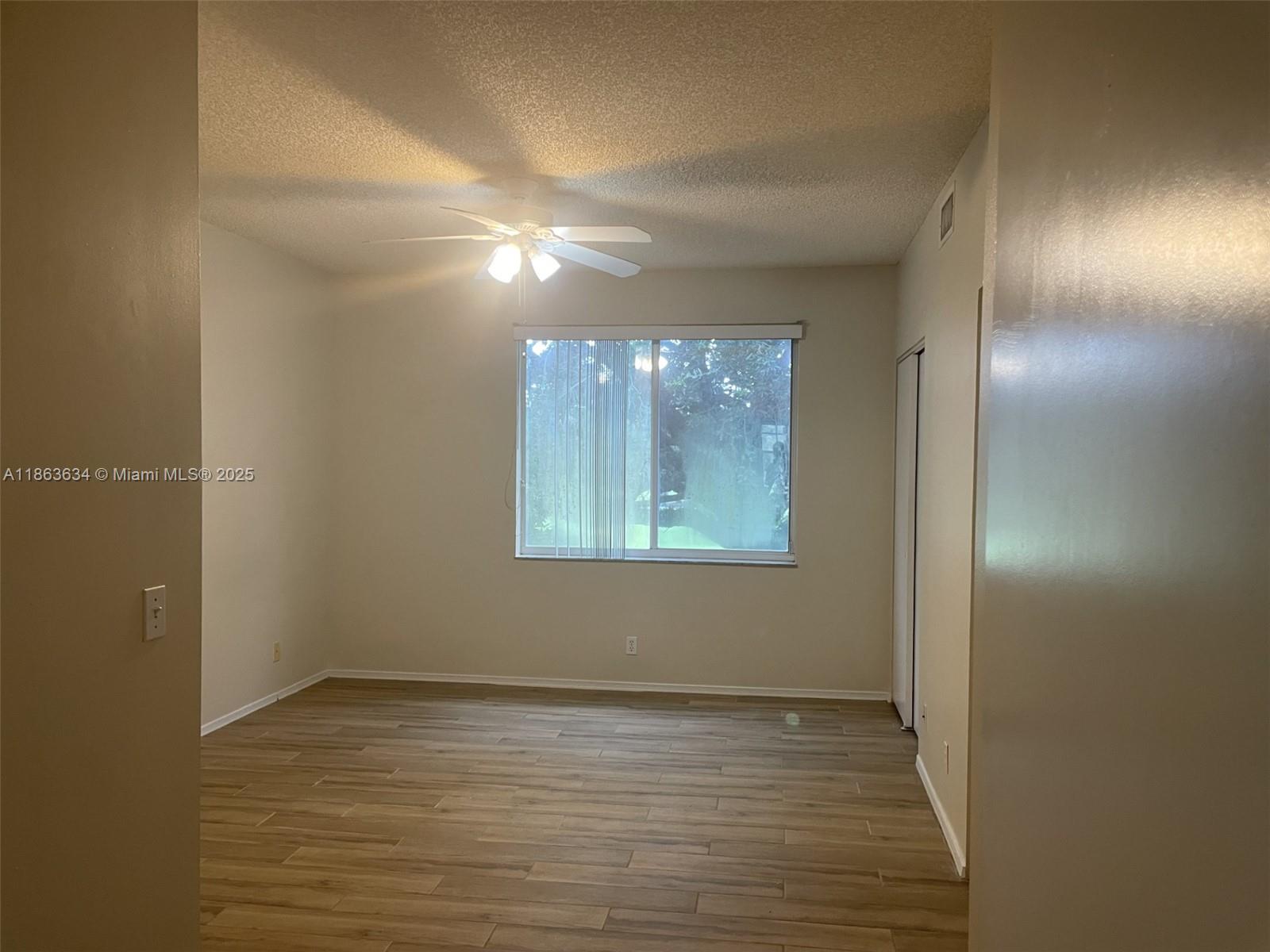 145 Southwest 96th Terrace, Unit 145 Plantation, FL 33324 - Photo 28 of 39 a view of an empty room with wooden floor and a window