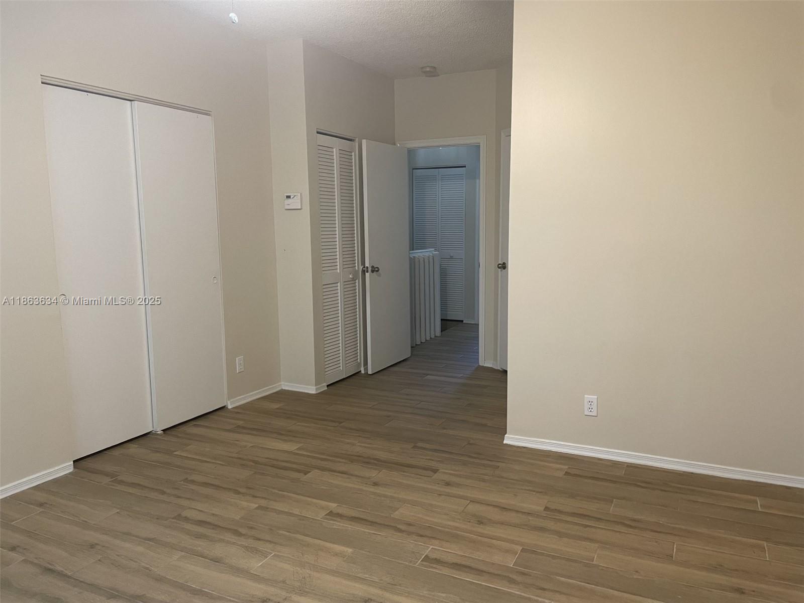 145 Southwest 96th Terrace, Unit 145 Plantation, FL 33324 - Photo 29 of 39 a view of an empty room with wooden floor and a window