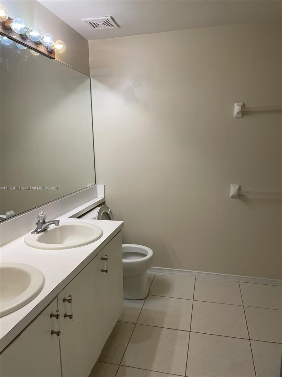 145 Southwest 96th Terrace, Unit 145 Plantation, FL 33324 - Photo 34 of 39 a bathroom with a sink a toilet and a mirror