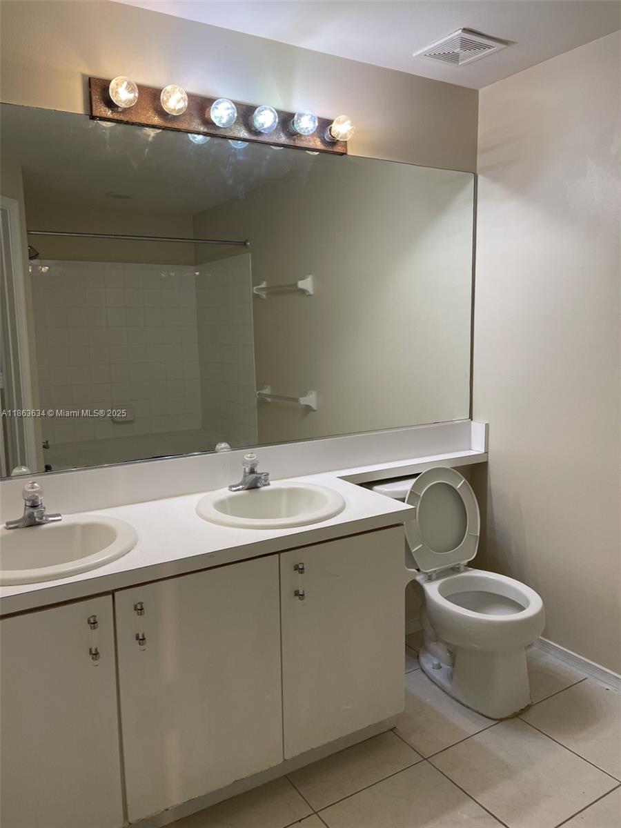 145 Southwest 96th Terrace, Unit 145 Plantation, FL 33324 - Photo 35 of 39 a bathroom with a toilet sink and mirror