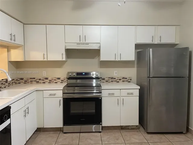 a kitchen with white cabinets and white appliances