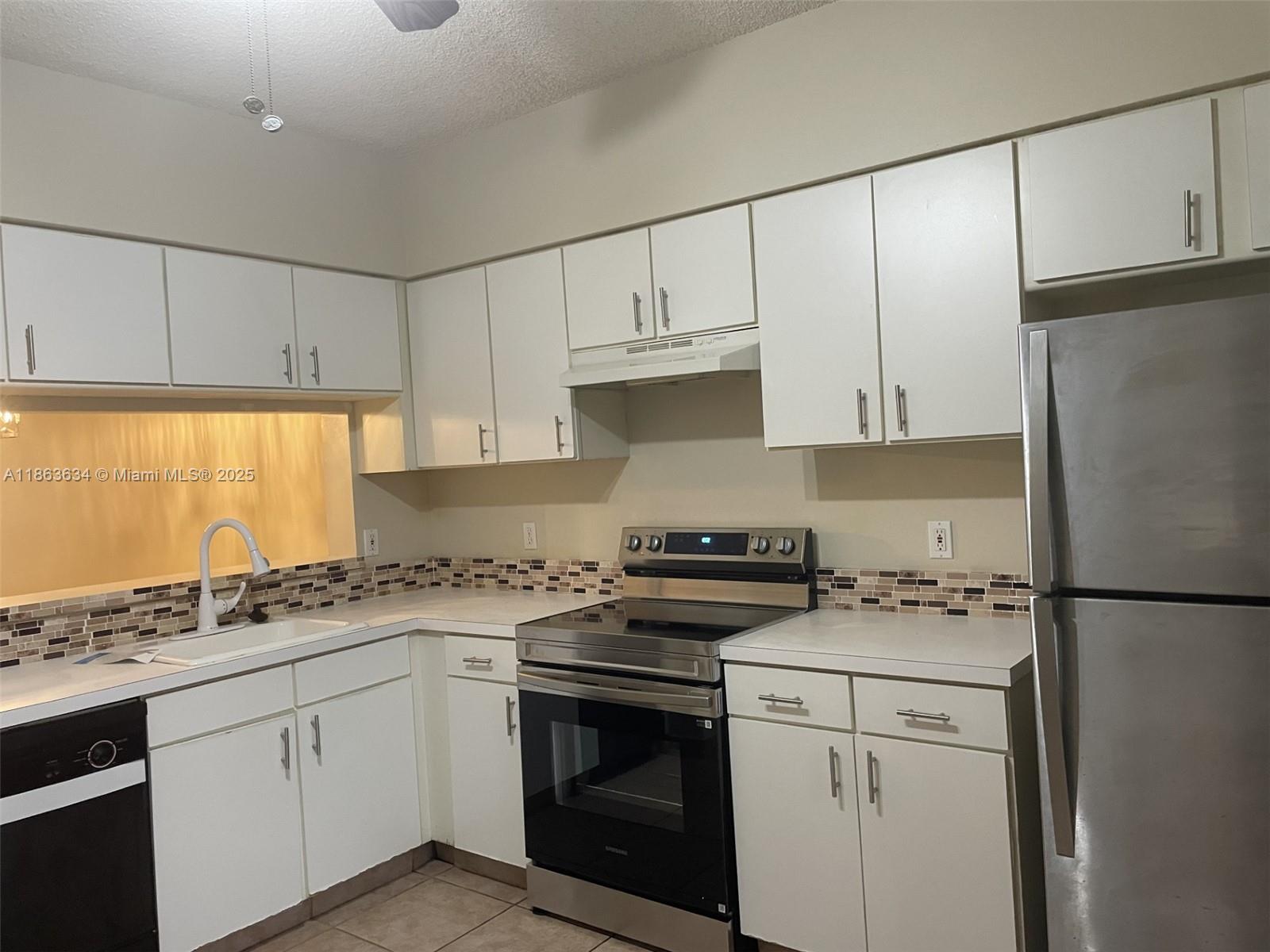 145 Southwest 96th Terrace, Unit 145 Plantation, FL 33324 - Photo 39 of 39 a kitchen with granite countertop cabinets stainless steel appliances and sink
