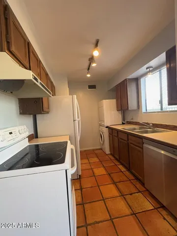 a kitchen with stainless steel appliances granite countertop a sink and a stove