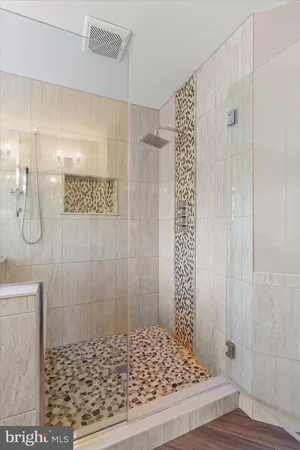 a view of a white house next to a yard with big trees and plants