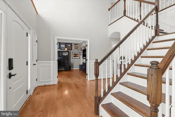 a living room with couches and a dining table with wooden floor