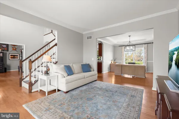 a kitchen with stainless steel appliances granite countertop a stove a sink dishwasher a dining table and chairs with wooden floor