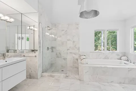 a bathroom with a tub sink and a shower